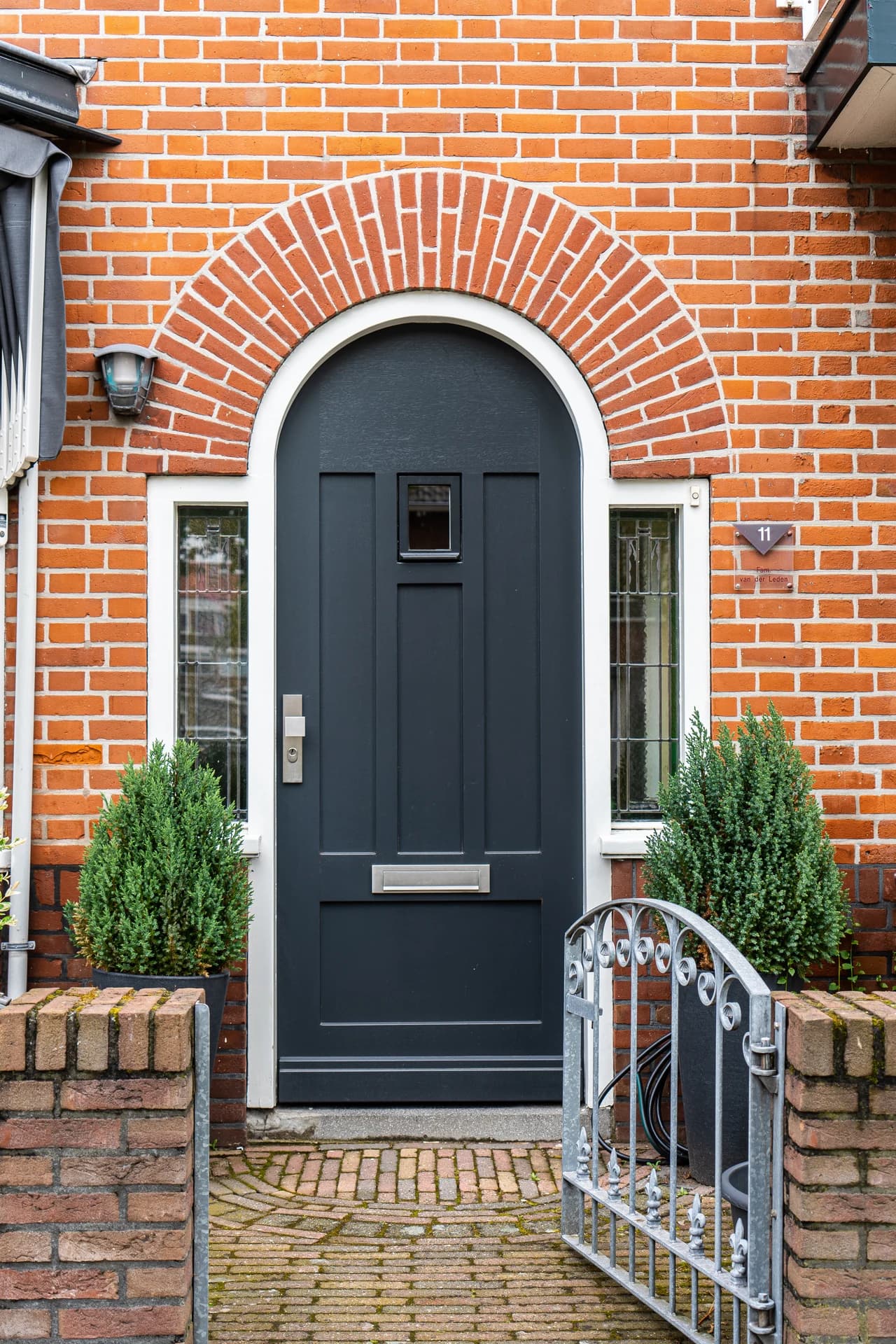 Anthracite grey composite front door with an arched brick surround installed in Neath