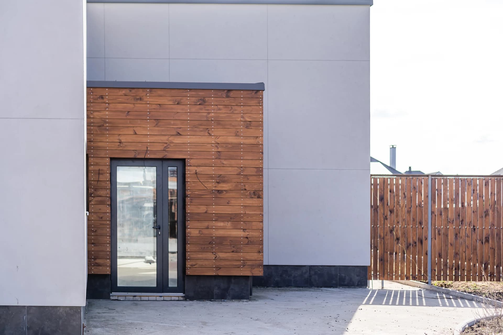 Modern black-framed glazed door on a timber-clad extension in Neath