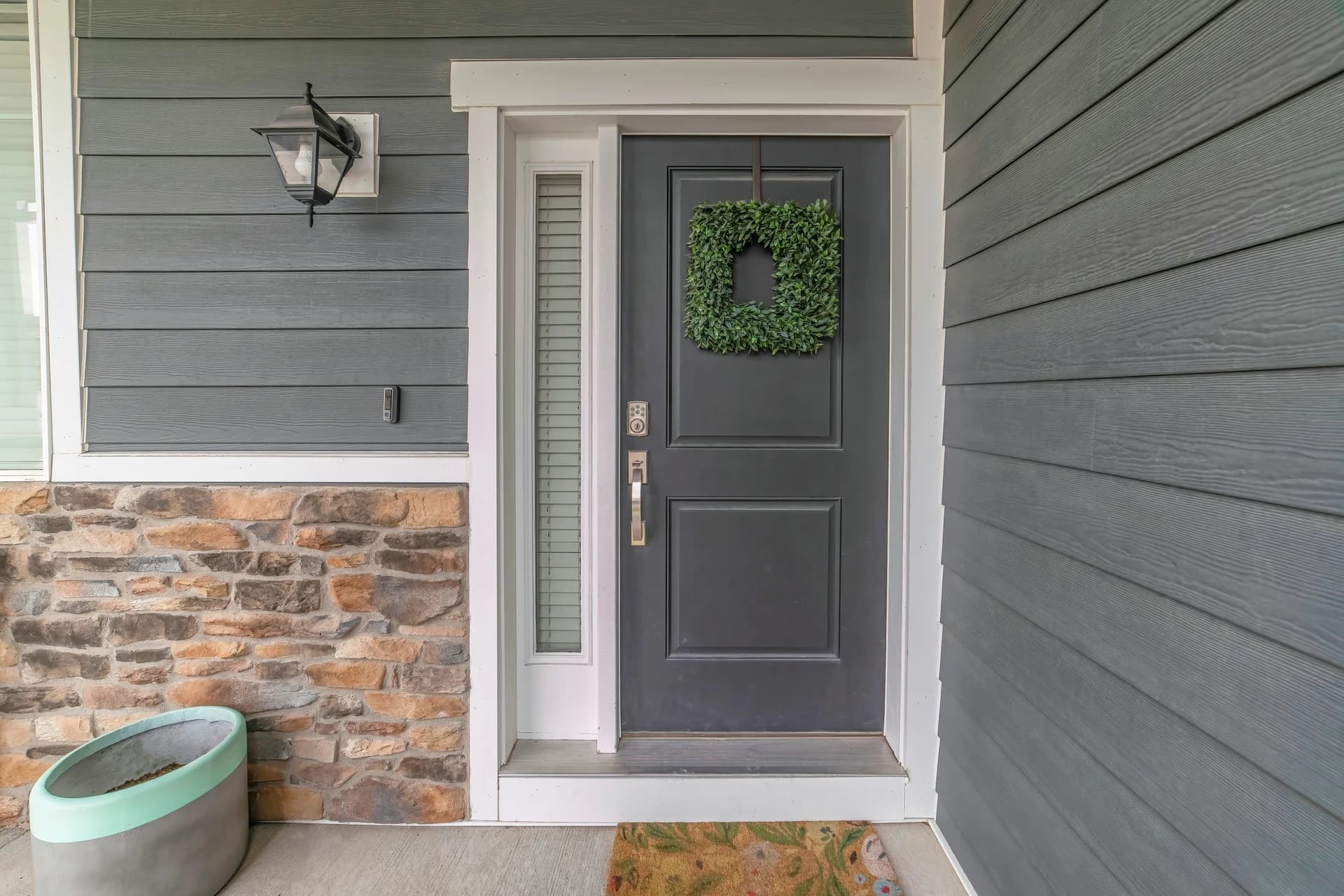 Grey composite front door with a glazed side panel on a modern home in Neath